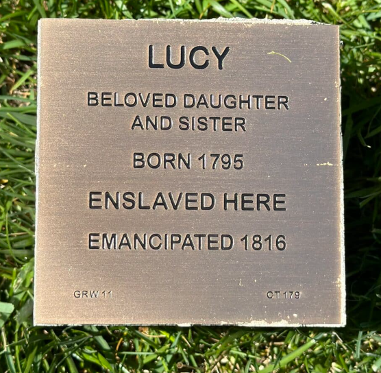 Bronze plaque honoring Lucy: Born 1795, enslaved here, emancipated 1816. Beloved daughter and sister.