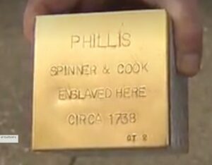 A picture of a person holding a Witness Stone. This was taken from the video news story that aired on News8.