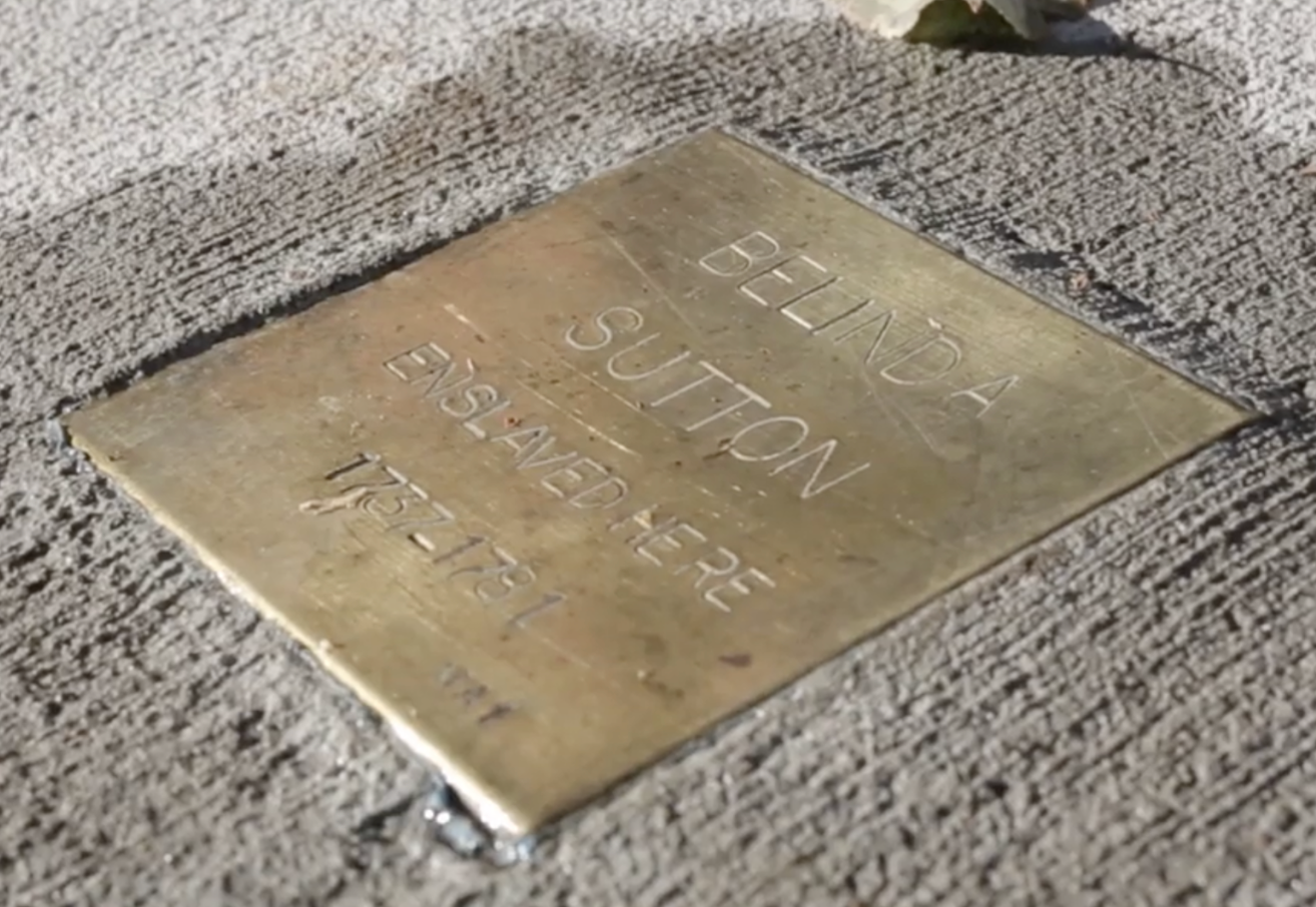 Historical plaque honoring Belinda Sutton, commemorating her story and legacy, engraved on a textured stone surface.