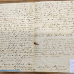 Historic handwritten letter from 1779 discussing land and family matters, placed on a wooden table.